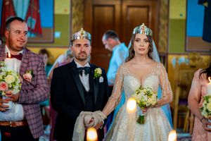 Wedding ceremony scene with couple wearing crowns during traditional Orthodox Christian marriage ritual.