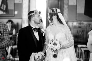 Black and white photo of Orthodox wedding ceremony with couple wearing ceremonial crowns.
