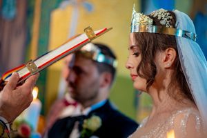 Close-up profile view of couple during traditional Orthodox wedding crown ceremony.
