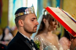 Side angle of Orthodox wedding ceremony showing ceremonial crowns against yellow background.