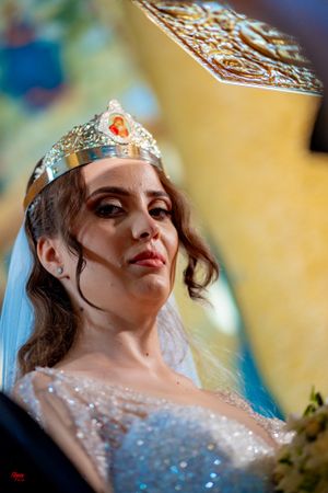 Close-up view of a bride in a crystal crown and beaded dress at her wedding ceremony.