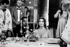 Black and white photo of Orthodox wedding ceremony with candles and religious artifacts on altar.