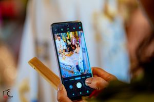 Wedding guests capture special moments on their smartphones during the ceremony.