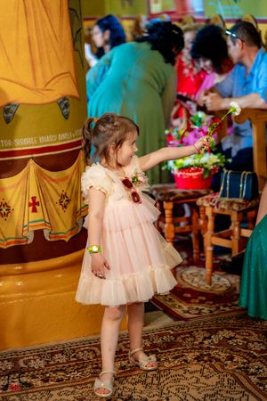 Young girl in pink dress twirling on patterned carpet at wedding reception.