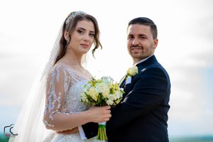 A bride and groom share an intimate moment against a bright outdoor background.