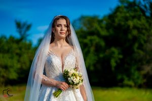 Outdoor bridal portrait featuring a white wedding gown and yellow floral bouquet.
