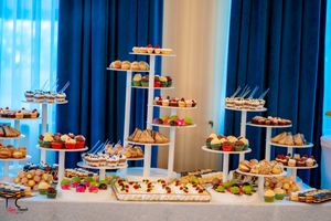 Long buffet table with tiered dessert stands displaying various pastries and treats.