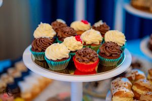 Gourmet cupcakes with chocolate and vanilla frosting displayed on white plates.