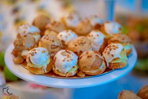 Small bite-sized appetizers arranged on white serving plates with garnishes.