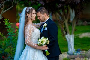 Intimate wedding moment captured in an outdoor garden with lush greenery and flowers.