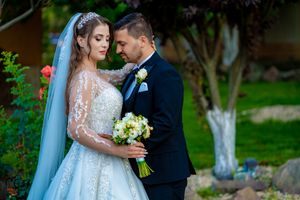 Beautiful wedding photography showing a couple in a garden with a flowing white dress and veil.