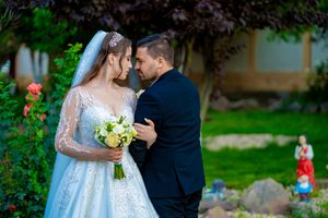 Garden wedding portrait with yellow bouquet and classic formal attire.
