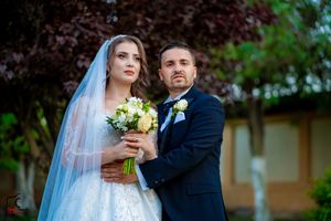 A newlywed couple shares an intimate moment during their outdoor wedding photoshoot.