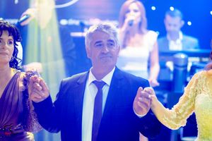Celebration event with guests in formal attire under atmospheric blue lighting.