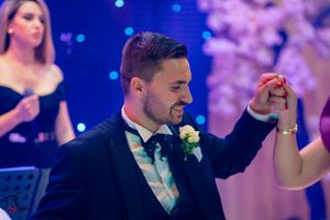 Formal event guests dancing and celebrating under blue and purple mood lighting.