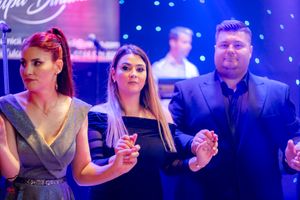 Formal gathering with guests socializing under vibrant mood lighting and starry effects.