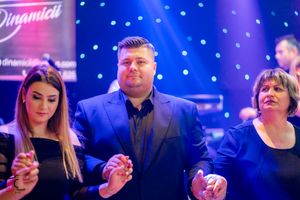 Corporate event with attendees under dramatic blue lighting and illuminated backdrop.