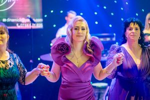 Festive celebration with guests dancing under colorful disco lights and sparkles.