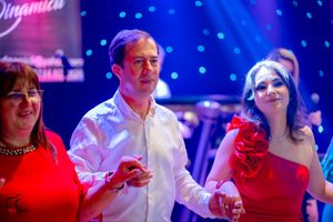Partygoers enjoying themselves under colorful nightclub lighting with blue and pink hues.
