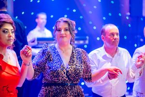 Social event featuring dancers in elegant attire under dramatic blue and purple lighting.