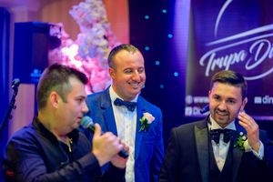 People laughing and enjoying themselves at an elegant evening event with blue and purple lighting.