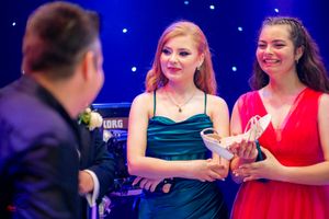 Attendees mingling at a formal event with vibrant blue lighting and decorative elements.