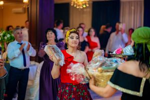 Guests dance and celebrate at an elegant indoor reception with warm lighting and chandeliers.