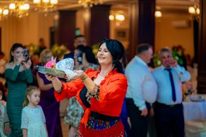 Partygoers in formal attire enjoying festivities in a warmly lit ballroom setting.