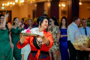 Person in bright red outfit dances energetically at formal event with crowd in background.