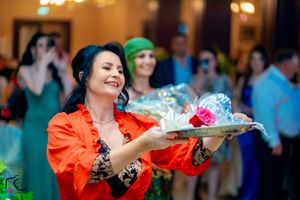 Dancer in vibrant orange dress performs dynamic moves at formal celebration.