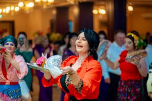Lively reception scene with dancers in bright outfits under warm lighting.