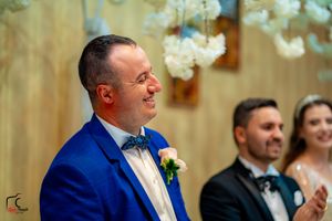 Wedding guests share laughter and smiles during an indoor reception celebration.