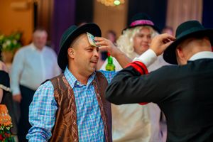 Party guests in western-style outfits socializing at an indoor event.