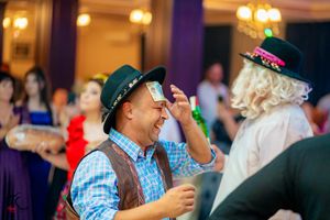 Festive party scene with guests in casual attire under warm lighting.