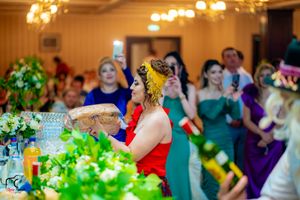 Banquet hall decorated with green centerpieces and warm lighting for a celebration.