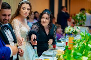 Elegant wedding reception with formal table settings and lush green floral arrangements.