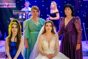 Wedding celebration with bridal party wearing coordinated green and purple dresses.