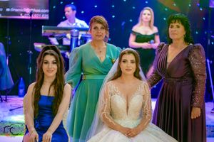 Festive gathering with attendees in formal wear under dramatic blue stage lighting.