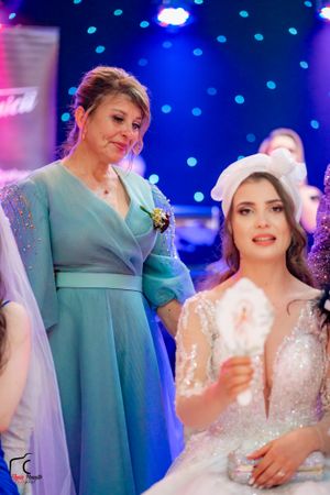 Wedding party members interact during reception with blue ambient lighting and sparkly decorations.