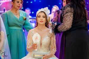Festive wedding reception with guests in formal wear under blue decorative lighting.