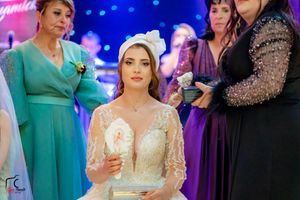 Wedding celebration with attendees in formal attire gathered under blue mood lighting.