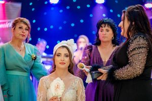 Indoor wedding reception showing guests in formal wear with blue ambient lighting effects.