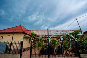 Panoramic view of residential buildings with red roofs under cloudy sky.