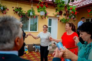Celebration with dancers in colorful attire on Spanish-style patio with climbing vines.
