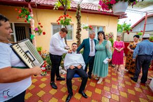 Wedding reception guests gather on a decorative tiled terrace with yellow walls and flowering vines.