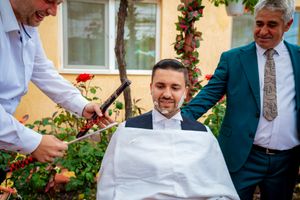Traditional barbershop service being performed outdoors during a formal celebration.