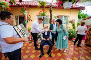 Musicians perform at an outdoor celebration with accordion music on a decorated terrace.