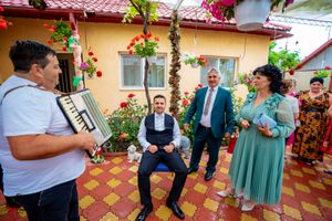 Lively outdoor celebration with music and dancing on a flower-adorned patio.