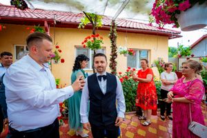 Outdoor celebration with floral decorations and climbing roses against stucco wall.