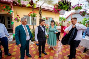 Festive gathering on a tiled patio with colorful floral decorations and yellow stucco walls.